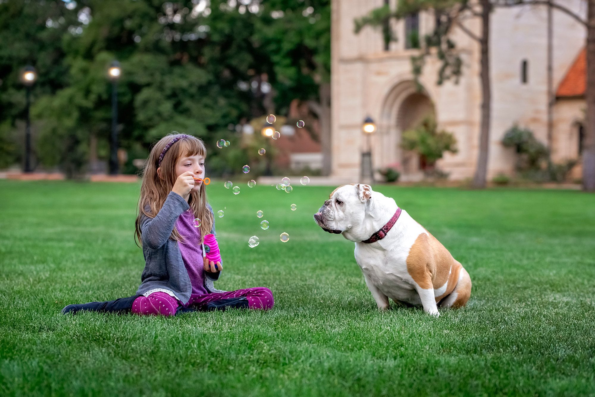Girl blowing bubbles for her dog